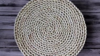 Yuvarlak örülmüş sümbül halı, ahşap bir arka planda mutfak için su sümbülü liflerinden yapılmış.