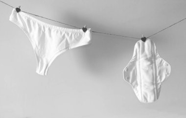 Yeniden kullanılabilir ped ve kadın külotları iple kurudu. Siyah beyaz fotoğraf