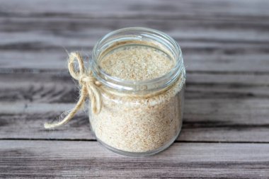 Psilyum, muz tohumu kabuğunun ahşap arka planda bir kavanozdaki bitkisel ürünü. Faydalı diyet takviyesi, süper yiyecek.