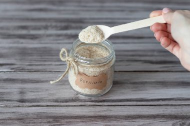 Psilyum bir muz kabuğudur. Kaşıklı kavanoz ve ahşap arka planda 