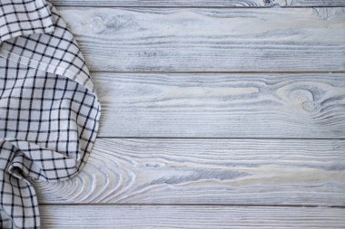 Tekstil peçeteli eski ahşap masa ya da yanında keten mutfak havlusu. Uzayı metin için kopyala. Tasarım için düzenName.