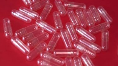 Empty powder filling capsules on a red background