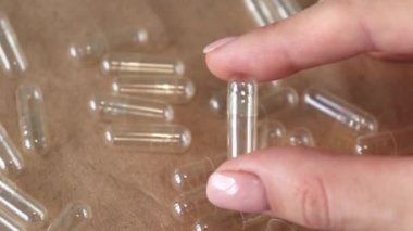 A woman holds an empty capsule in her hand. Macro video