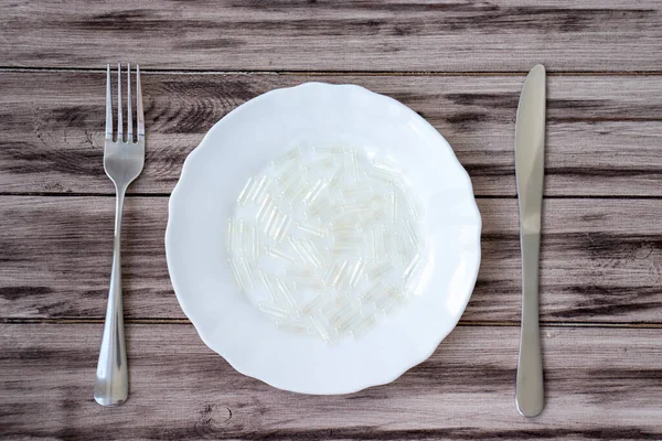 Empty Pill Vitamin Capsules White Plate Cutlery Wooden Table — стоковое фото