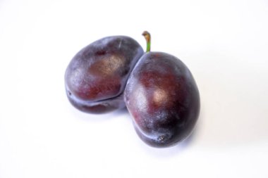 Ugly double prune or French plum in the shape of a heart on a white background. Selective Focus. The concept of Ugly Fruits