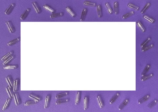 Lilac frame with empty capsules for pills, vitamins and supplements. Frame with white space for text.