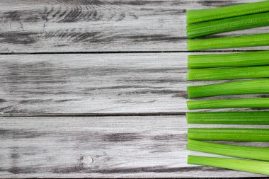 Stalks of green celery on a wooden background. Healthy eating concept, food base. Vegetable frame with space for text