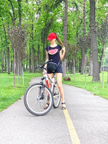 一个骑自行车的苗条身材的女孩在公园里歇息一下 — 图库照片