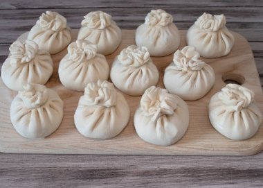 Dondurulmuş çiğ hamur köftesi, dana eti ve kuzu eti. Geleneksel Gürcistan çiğ donmuş khinkalisi ahşap yüzeyde.