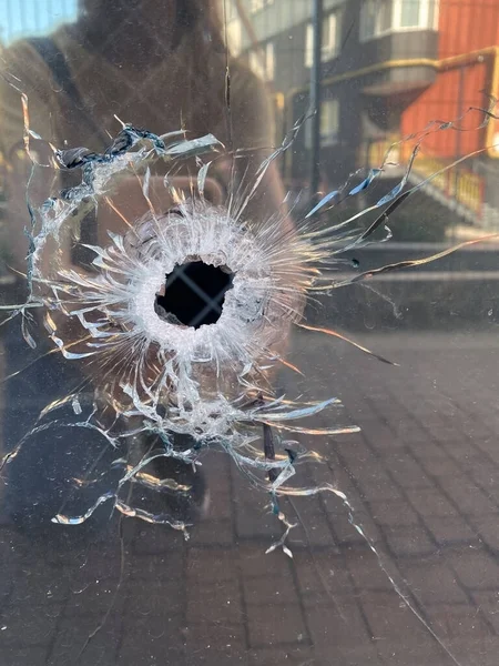 Store window with mirror glass pierced by a bullet.