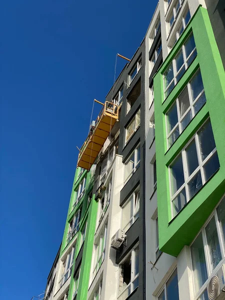 Aerial work platform at facade installation work. Working elevator high up on a high-rise. Repair and installation of a broken facade
