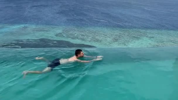 Mężczyzna Pływa Turkusowym Basenie Tle Oceanu Malediwach Basen Dachu Domu — Wideo stockowe