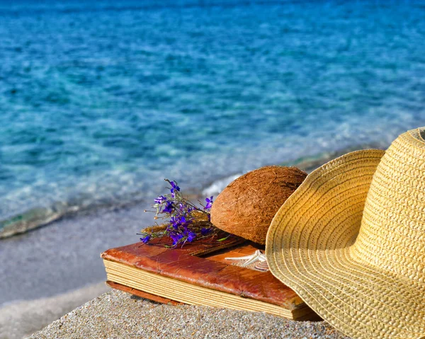 Romantic landscape on the ocean. Coconut with a bouquet of flowers and a photo album.