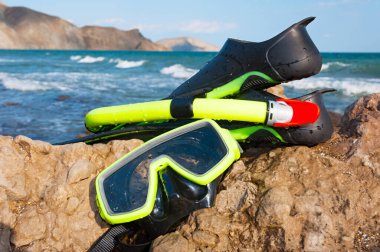 Dalış aksesuarları. Maske, şnorkel ve yüzgeçler güneşli bir yaz gününde deniz kıyısında..