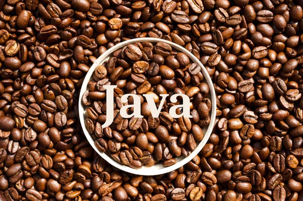 Java. Roasted coffee beans in a paper cup lid against the background of beans. Grains of a tropical plant. Environmentally friendly glass.
