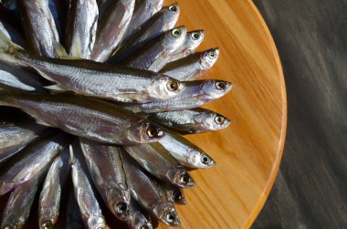 Dried fish bleak on a wooden board. Very tasty, fatty fish for beer.