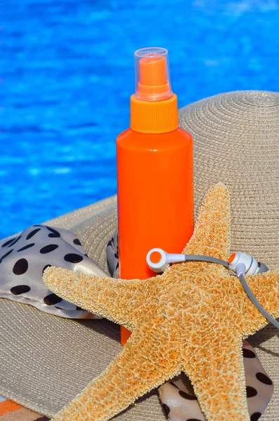 Zeester Koptelefoon Zonnebrandspray Dameshoed Achtergrond Van Het Zwembadconcept Van Ontspanning — Stockfoto