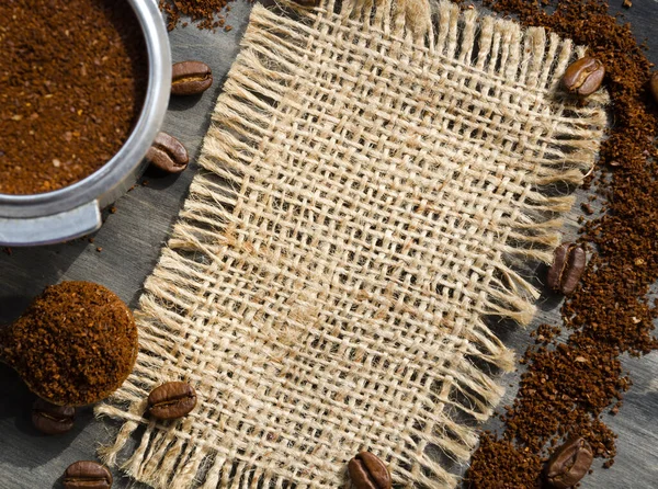 Coffee cone with ground coffee lie on coffee beans on burlap. Photo for advertising a coffee shop. Menu of coffee drinks.