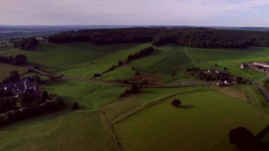 Doğal çitleri olan güzel tepeler, ormanlar ve çayırlar Beusdael Kalesi ile kırsal yollar, arka planda mor gökyüzü, Güney Limburg, Maastricht ve Vaals yakınlarında. Yaz mevsiminde hava aracı görüntüsü. Hollanda 'nın altın saati.