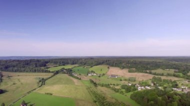 Panorama Aerial View: Hollanda köy manzarası yuvarlak tepeler ve tarım arazileri, küçük bir köye sahip çayırlar, açık mavi bir gökyüzü, üç ülke noktası Vaals