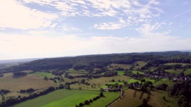 Panorama Aerial View: Hollanda Vadisi 'nin kayan tepeler ve köyler, orman ve küçük Vaals kasabası üzerindeki manzarası. Güney Limburg 'daki Üç Ülke Noktası Mavi gökyüzü ile Hollanda