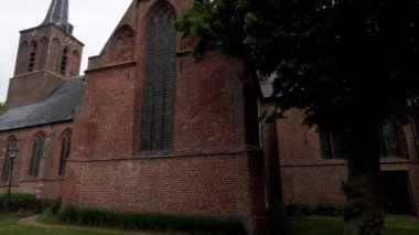 Hollanda 'nın Schellinkhout kentindeki küçük bir köyde güzel Gotik vitraylı pencereli kilise çan kulesinden daha az manzaralı 14. yüzyıl manzaralı bir yer.