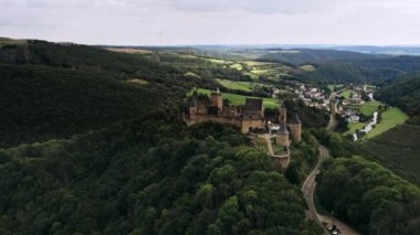 Bourscheid Kalesi. Dağın tepesinde güzel bir romantik şato vadide bir köy, nehir, çayırlar, tepeler ve ormanlar. Lüksemburg. Yüksek Açı Çekim Havadan Görünüm