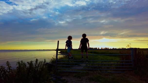 Dois Meninos Assistindo Bela Vista Céu Quente Colorido Pôr Sol — Vídeo de Stock