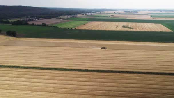 밭에서 농기계와 일하는 농부를 공중에서 여름에 남쪽의 보르그의 목초지에서 황록색 — 비디오
