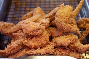 Yağı süzmek için kevgirde kızarmış tavuk kanadı..