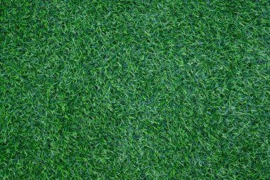 Metin arkaplanı için fotokopi alanı olan bahçede yeşil yapay çimlerin yakın plan görüntüsü.