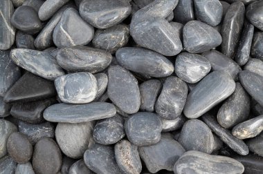 Gri taşların doğal arka planı, bahçe dekorasyonu için zeminde yuvarlak şekillidir..