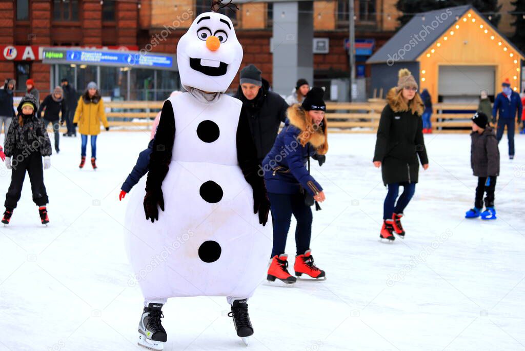 A funny snowman is skating on a skating rink in winter. Sports clubs, active family sports, entertainment for children for winter holidays, Christmas and New Years. Dnipro city, Ukraine
