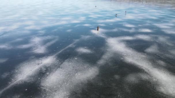冬天一架无人驾驶飞机在冰冷的背景上飞行 渔夫们在美丽的蓝冰上钓鱼 冰封在河边 冬日在湖面 尽收眼底 — 图库视频影像