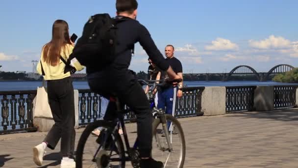 人们在河边散步 骑自行车和摩托车 春天的娱乐活动 乌克兰第聂伯罗夫斯克市的体育运动 2021 — 图库视频影像