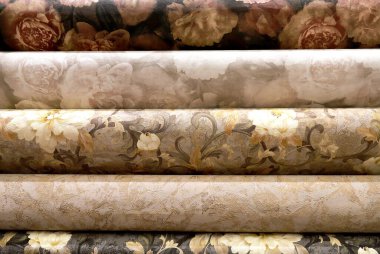 İnşaat malzemeleri mağazasında plastik duvar kağıdı ruloları. Arka plan olarak çeşitli doku ve renkler. Duvar için çiçek desenli duvar kâğıdı, tamir malzemeleri.