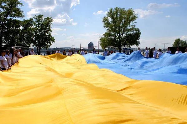 İnsanlar Ukrayna 'nın en büyük bayrağını taşıyor. Dnipro, Dnepropetrovsk 'ta büyük sarı ve mavi Ukrayna ulusal bayrağı. Ukrayna 'nın Vatanseverlik ve Bağımsızlığının Sembolü