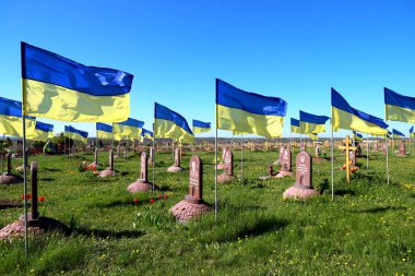 military cemetery where soldiers who died in Russian war against Ukraine are buried. State Ukrainian flag flutter over graves and monuments. Dnipro city, Ukraine, May 7, 2022. clipart
