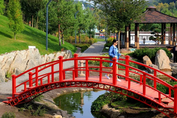 Dívka Kráčí Starém Červeném Dřevěném Mostě Přes Řeku Japonském Parku — Stock fotografie