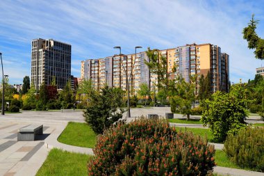 Yüksek evler, binalar, gökdelenler ve şehir manzarasına karşı güzel bir park. Ukrayna 'da bahar, yaz sokağı Dnipro, Dnepropetrovsk, Ukrayna