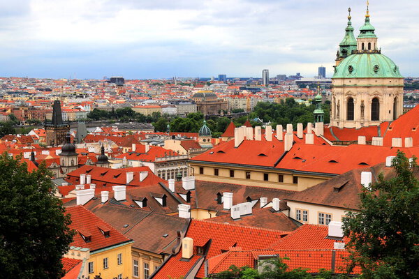 Prague, Czech Republic. Mala Strana, Lesser Town of Prague. Top view of downtown, panorama. Ancient old buildings with red tiled roofs, church, tower, castle