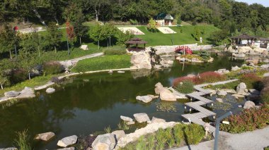 New Sofiyivka 'da Japon tarzı güzel bir peyzaj parkı. Göl, ahşap ağaçlar, kırmızı köprü, parktaki İHA 'dan havadan görüş. Uman, Ukrayna, 2021-09-12