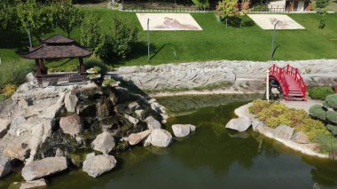 New Sofiyivka 'da Japon tarzı güzel bir peyzaj parkı. Göl, ahşap ağaçlar, kırmızı köprü, parktaki İHA 'dan havadan görüş. Uman, Ukrayna, 2021-09-12