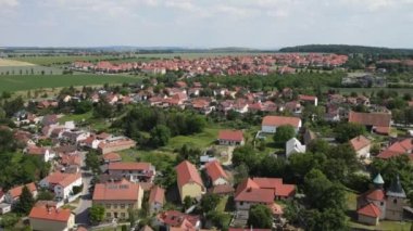 Flight over bohemian countryside with traditional village and red roofs, Czech Republic. Aerial view of town Czech 