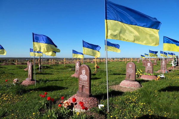 Military cemetery in Ukraine. Soldiers of Ukrainian army died in war of Russia against Ukraine and are buried here. The national flag of Ukraine flutters over the monuments. Dnipro, Ukraine, 07.05.202