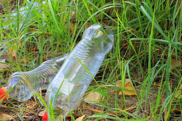 Plastic trash in grass. Plastic bottles and bags on the ground. Global environmental pollution, waste recycling