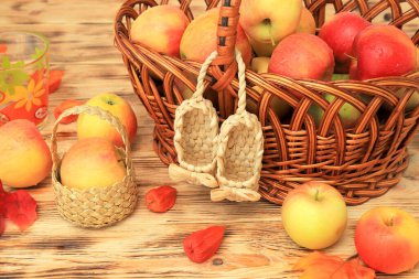 Red apples lie in wicker plate on wooden table. Ripe tasty apples for jam