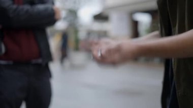 Şehir caddesinde kart numaralarını gösteren bir adamın yakın çekimi. Sihirbaz kartlarla sokak sihirbazlığı numarası gösteriyor - 4K Yatay Video