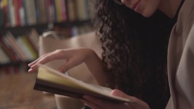Moroccan Girl Smiling While Reading Book. - close up - Horizontal