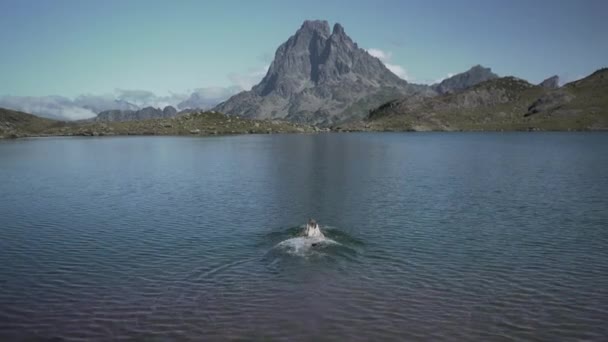 在法国比利牛斯的一个阳光灿烂的早晨 一位年轻的女士在清澈的蓝色湖中洗澡后走出了阿尤斯湖 水平4K视频 — 图库视频影像